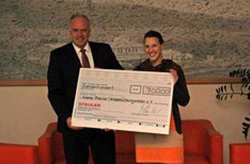 Andreas Grimm and Janina Duch hold the donation check for the Georg Steuler Support Association