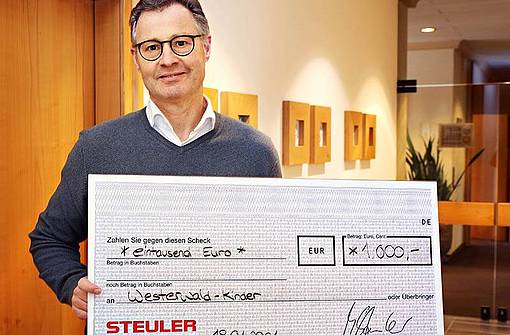 Geschäftsführer Michael Steuler hält den Spendenscheck für die Westerwaldkinder
